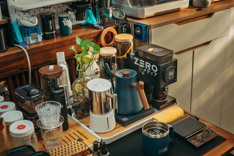 Cozy coffee corner setup in a small kitchen with mugs hanging on hooks and espresso machine on wooden shelf